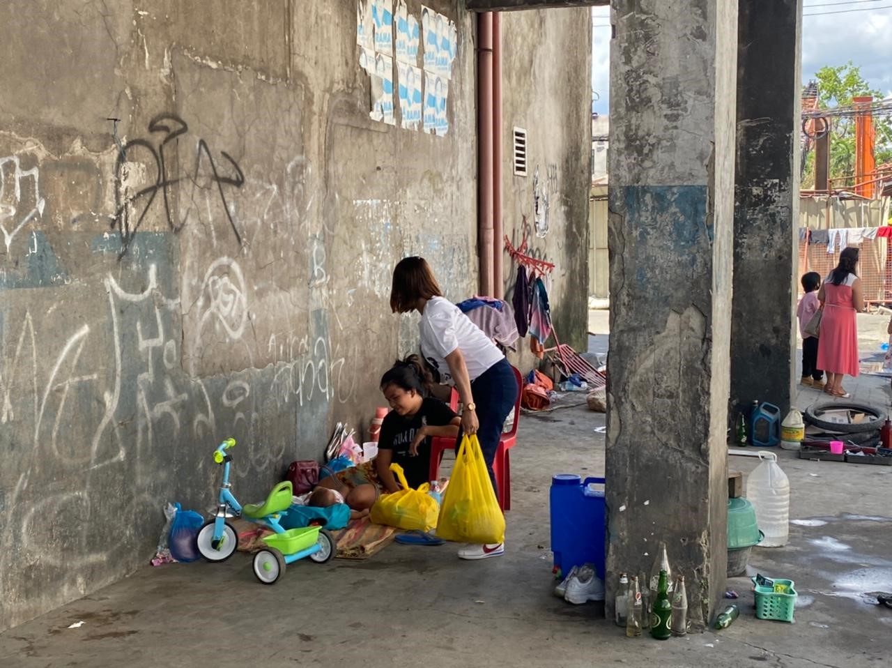 Voedselpakketten na tyfoon in de Filipijnen - Vrouw onder luifel met baby